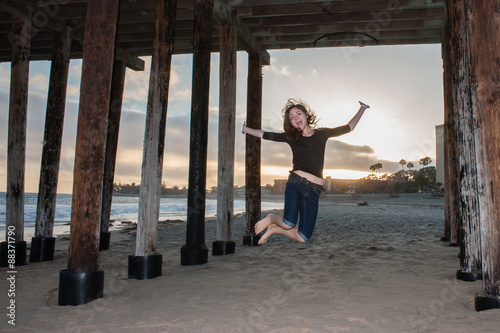 Midwest girl jumping for joy at California beach