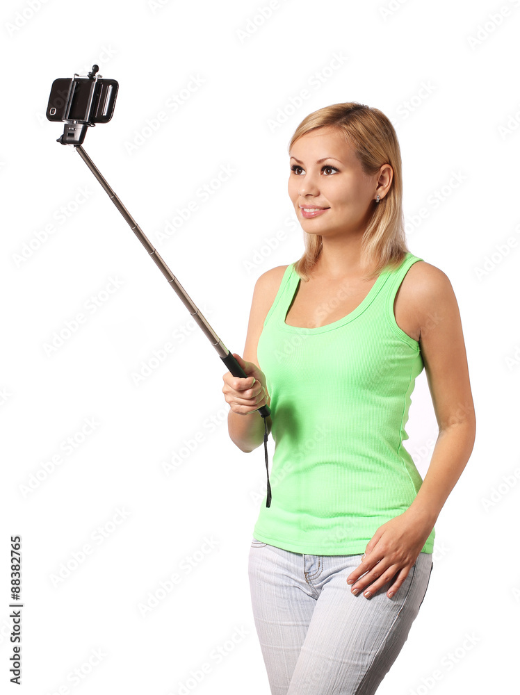 Young woman taking selfie photo with stick isolated on white Young woman taking selfie photo with stick isolated on white