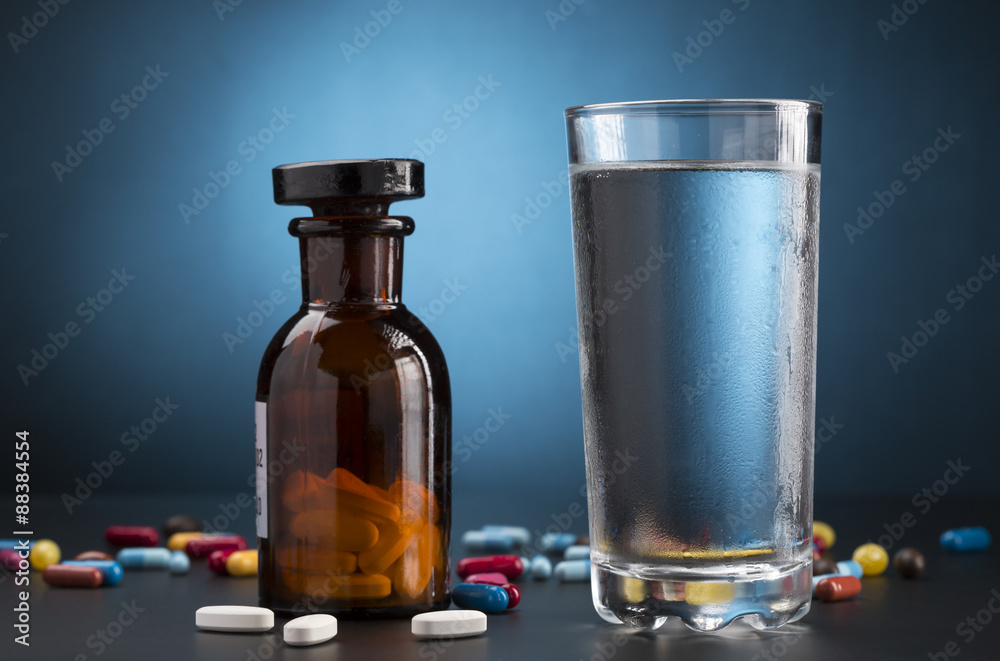 Medicine pills bottle and glass of drink water Medicine pills bottle and glass of drink water