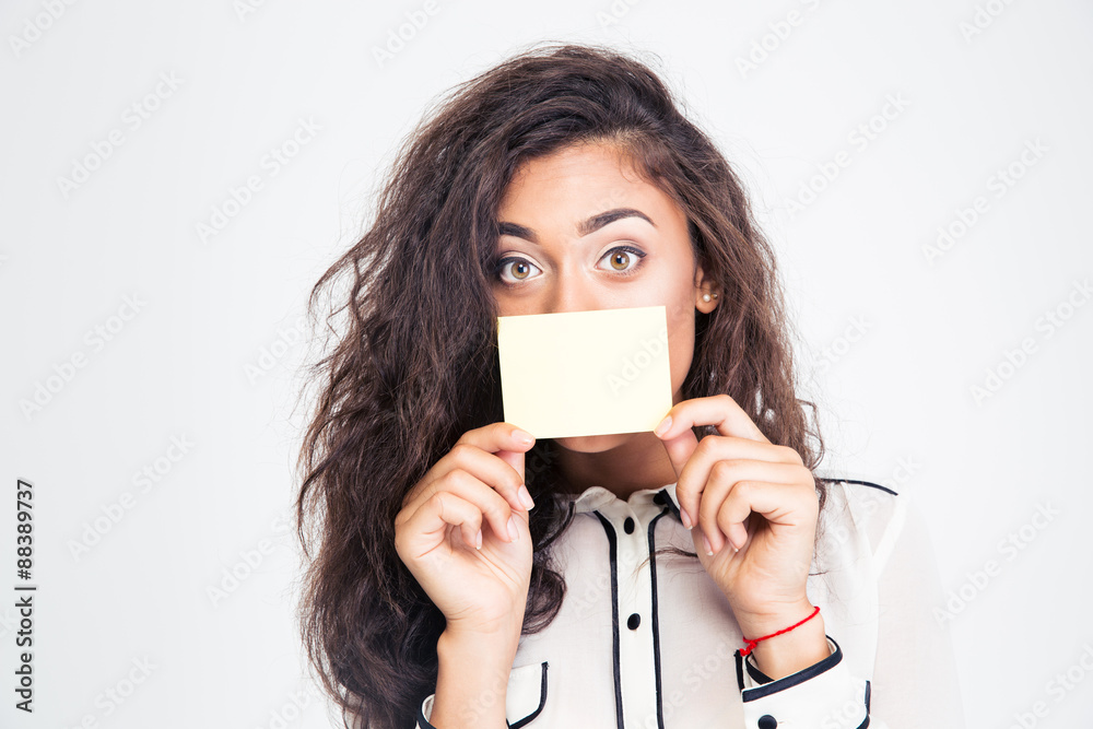 Businesswoman covering her mouth with blank card Businesswoman covering her mouth with blank card