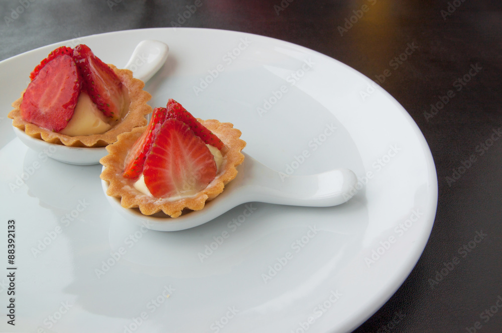 Two cheesecake with strawberries on white plate Two cheesecake with strawberries on white plate