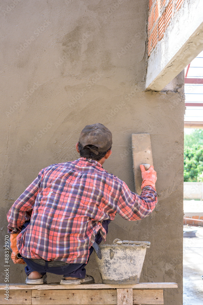 Builder worker plastering  concrete at wall