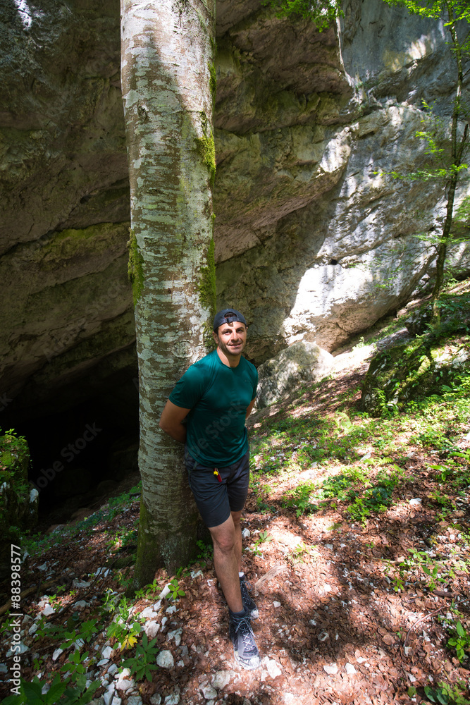 Naklejka premium Caucasian man near cave entrance