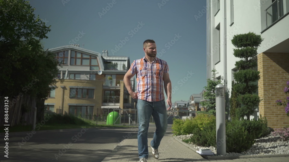 Walking young man aswering phone call.
Walking young man aswering phone call.