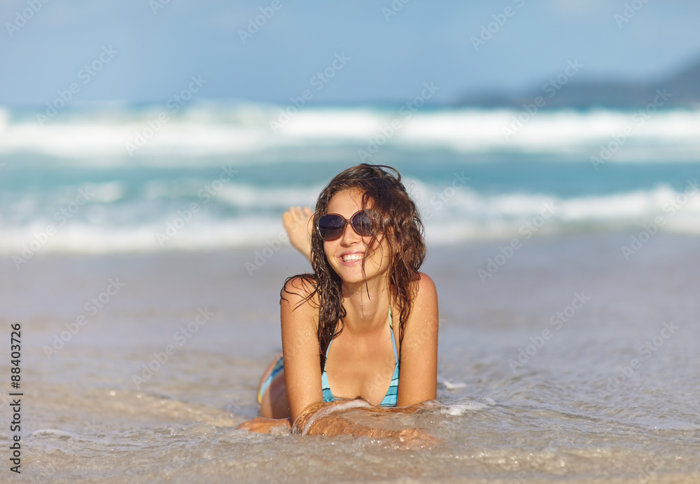 Smiling young woman laying on the beach Smiling young woman laying on the beach