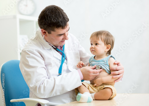 pediatrician examining hear...
