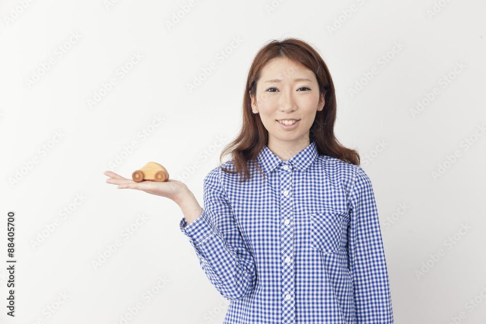車のおもちゃを持つ若い女性