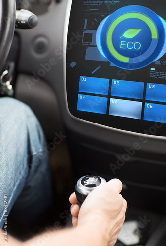 hand with gearshift and car eco mode on screen