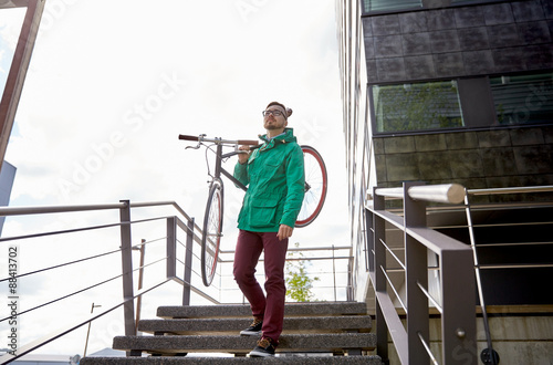 young hipster man carrying fixed gear bike in city © Syda Productions