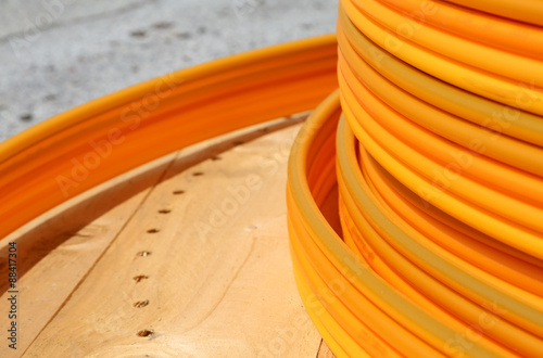 coils of orange plastic pipes for the installation of undergroun photo