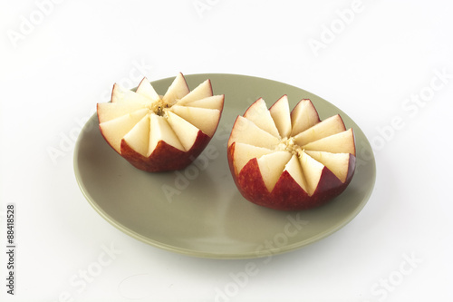 Cut red apple on a ceramic plate
