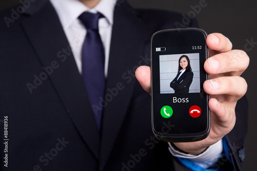 hand holding smart phone with incoming boss call