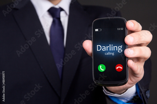 male hand holding smart phone with incoming call from darling