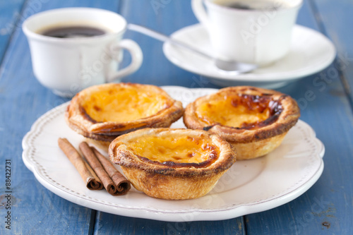 portuguese cookies on white dish with cups of coffee