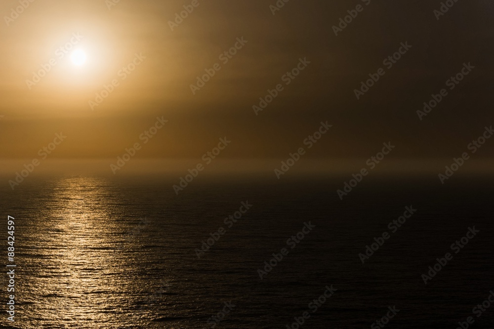 sun setting the mist of the atlantic ocean