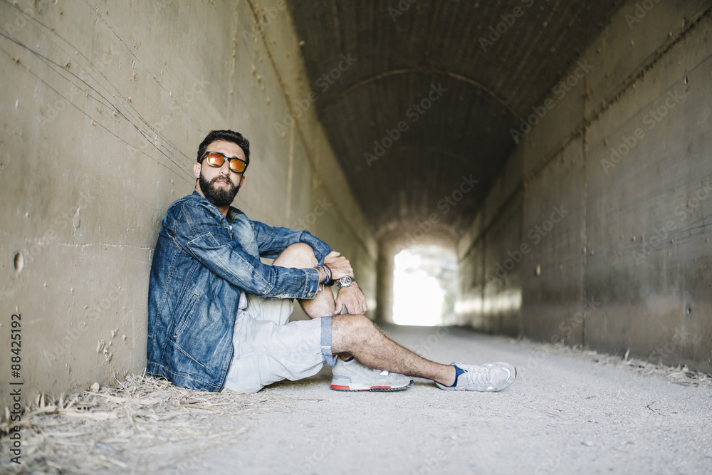 handsome young man in a tunnel with sunglasses