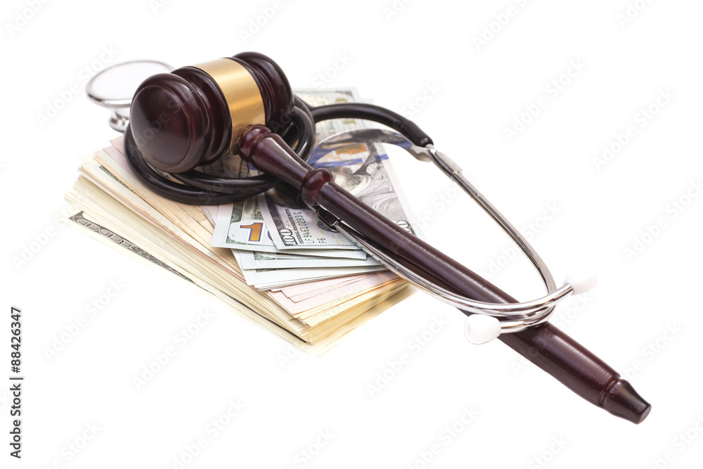 Stethoscope with judge gavel and dollar banknotes on white backg