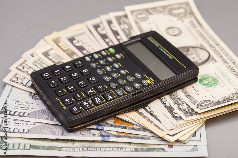 calculator on dollars isolated on gray background calculator on dollars isolated on gray background
