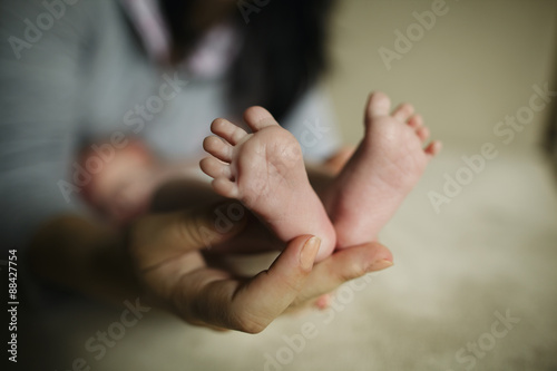 mother holding baby feet in hand © Aliaksei Lasevich