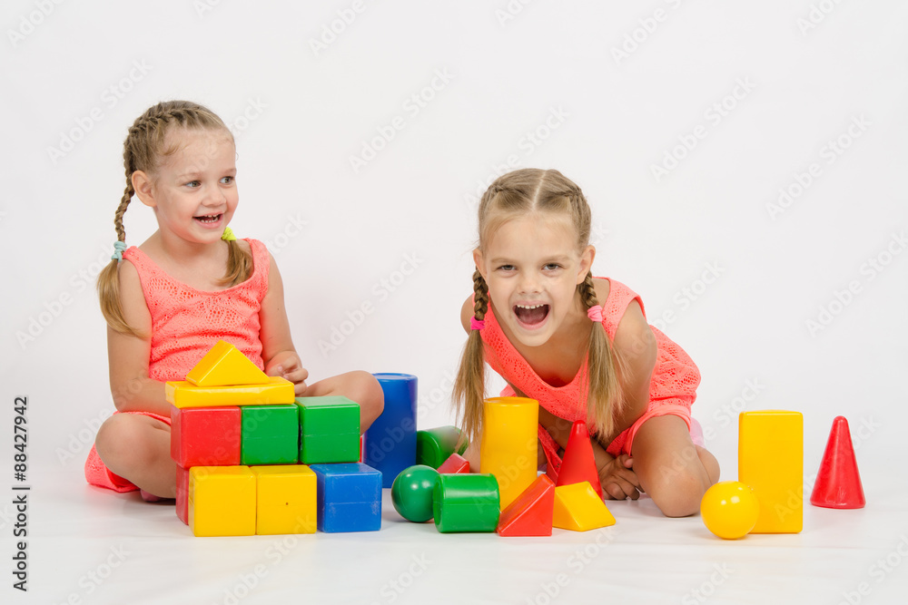 Two girls laughing uncontrollably playing dice Two girls laughing uncontrollably playing dice