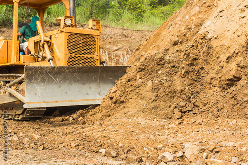 industrial bulldozer moving earth and sand in sand pit or quarry