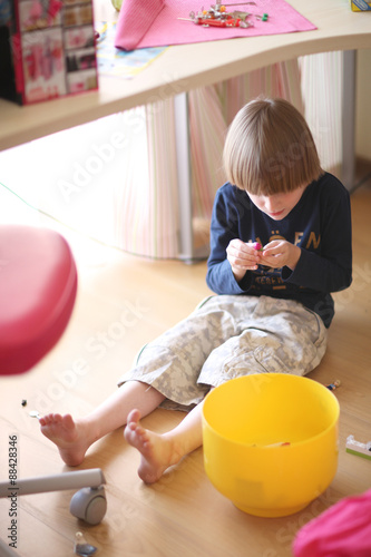 Caucasian boy playing with small details trying to interlock them