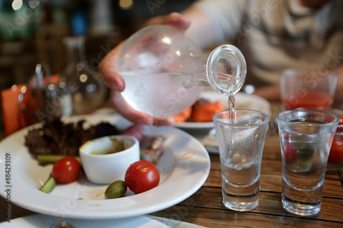 Person pouring vodka from the decanter