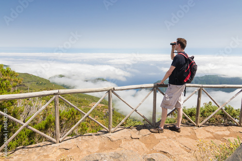 Man looking into binoculars in Madeira viewpoint