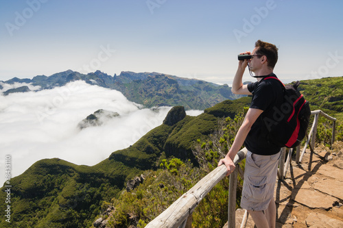 Man looking into binoculars in Madeira viewpoint