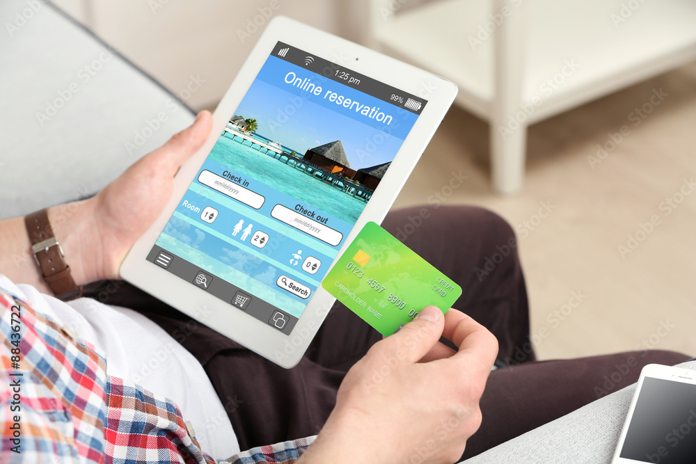 Wunschmotiv: Man holding tablet with screen interface of booking hotels #88436722