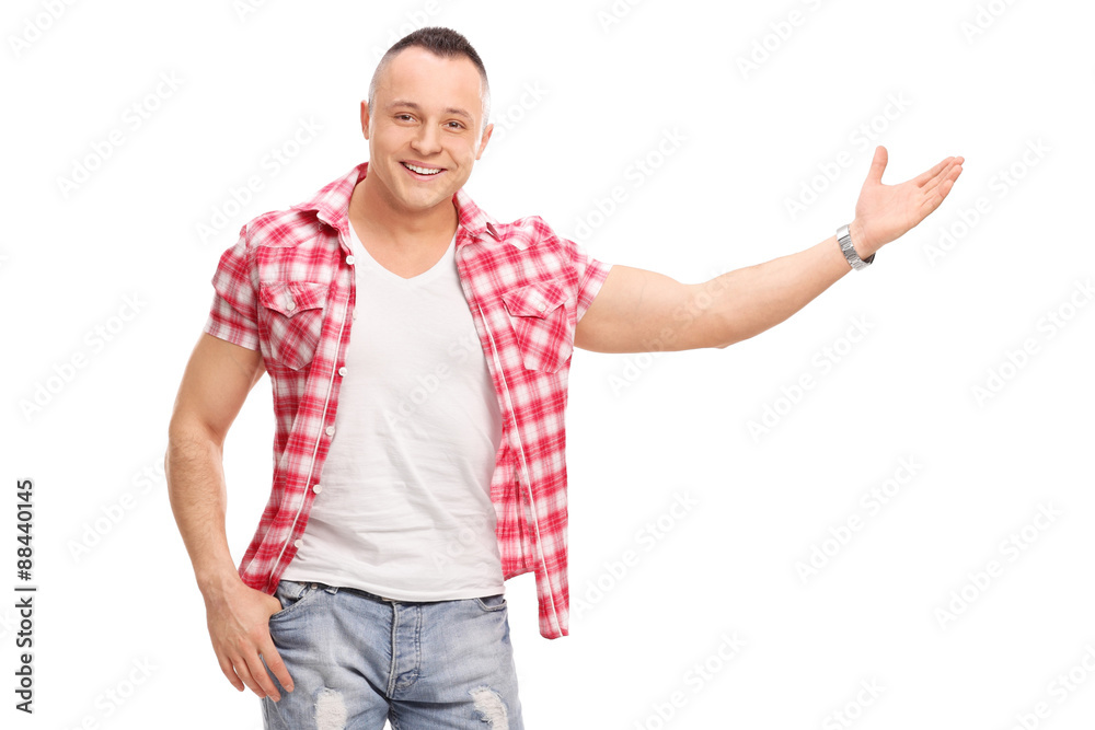 Casual young man gesturing with his hand and looking at the came