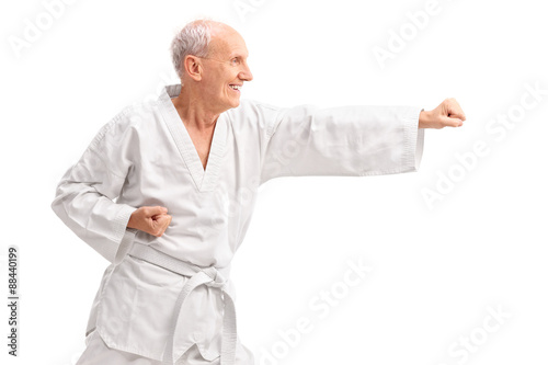 Old man in a white kimono practicing karate