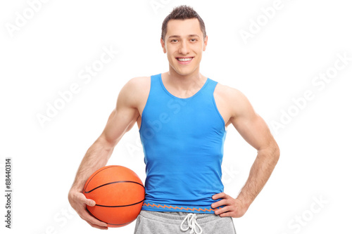 Young athlete in a blue jersey holding a basketball and looking