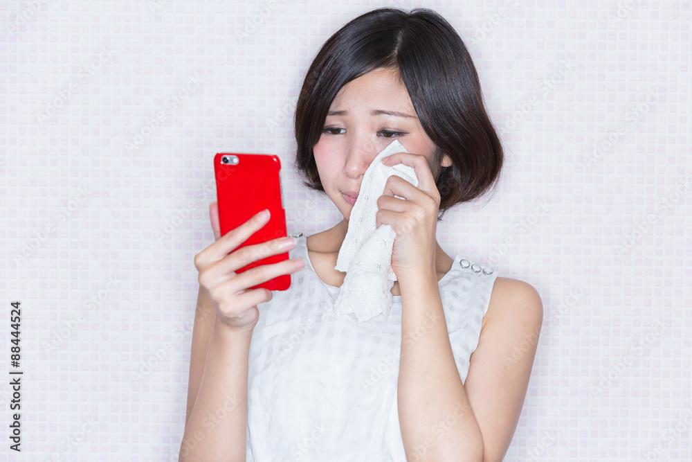 スマホを見て泣く女性 Stock Photo Adobe Stock