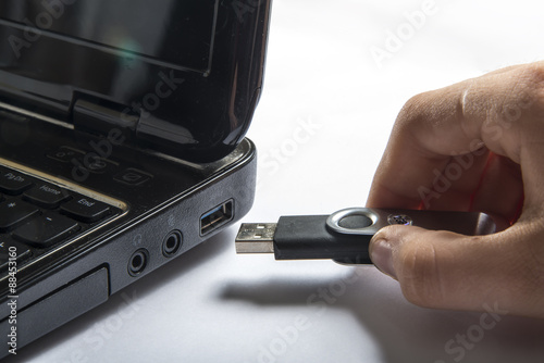 Hand inserting usb memory stick to laptop computer

