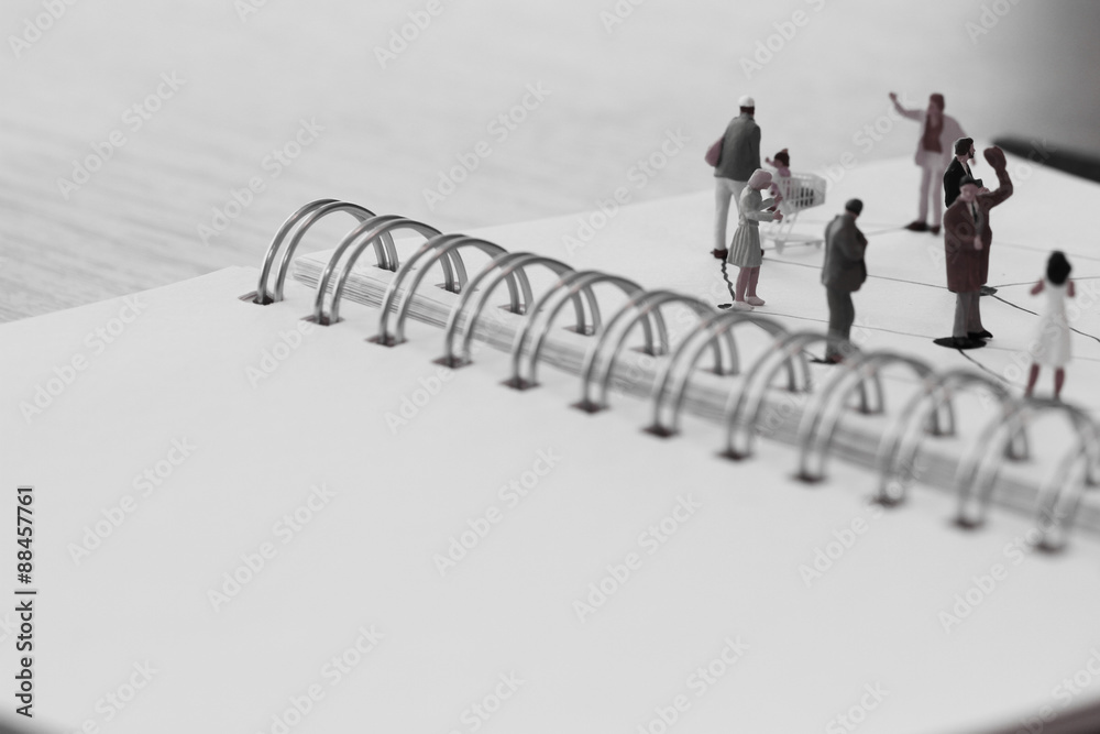 close up of miniature people with social network diagram on open close up of miniature people with social network diagram on open