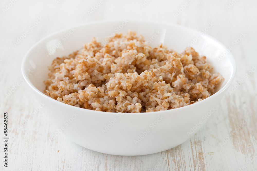 boiled cereals in white bowl on white wooden background boiled cereals in white bowl on white wooden background