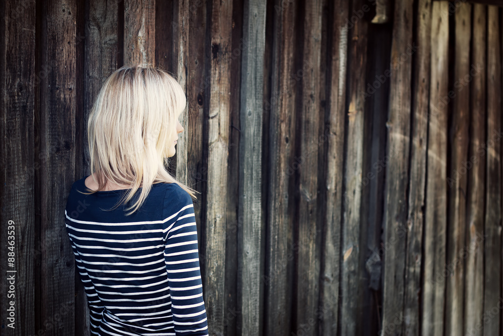 Fototapeta premium Young woman portrait infront of old wooden wall