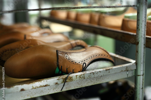 Regał w pracowni szewskiej z ustawionymi parami eleganckich męskich butów