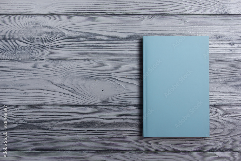 Fototapeta premium Blank book cover on textured wood background. Copy space