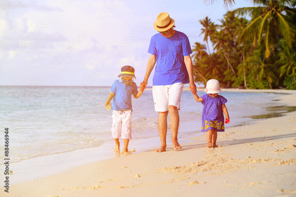 father and two kids walking on tropical beach father and two kids walking on tropical beach