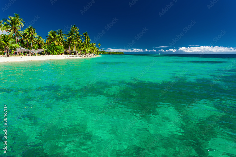 Tropical island in Fiji with beach and water with coral
