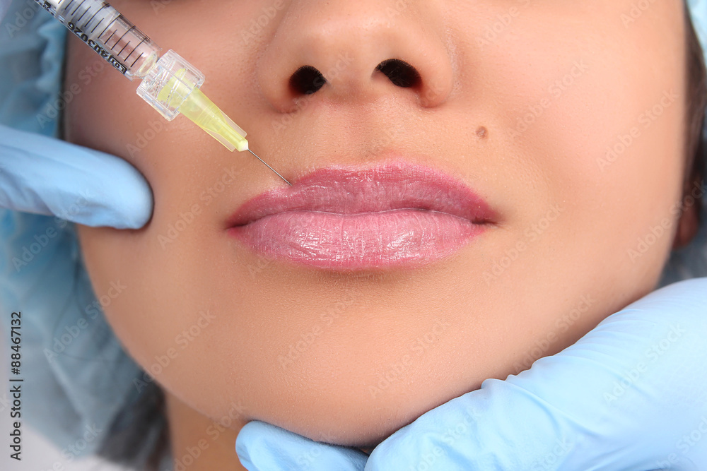 Beautiful woman gets an injection in her lips.