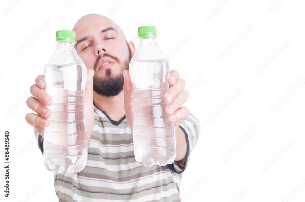 Thirsty man holding two bottles of cold water Thirsty man holding two bottles of cold water