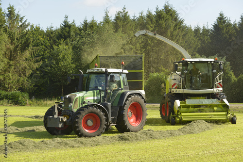 Agriculture, forage harvester and transport grass with green tra photo