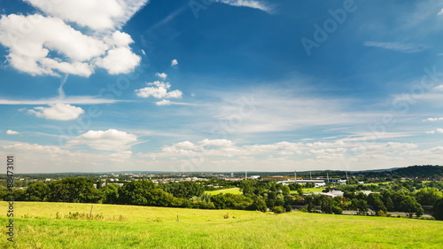 Panoramic view down to the north of Aachen with a meadow in the foreground, the Tivoli stadium in the center and the A4 motorway and the Lousberg to the right. Time lapse sequence zooming in. photo