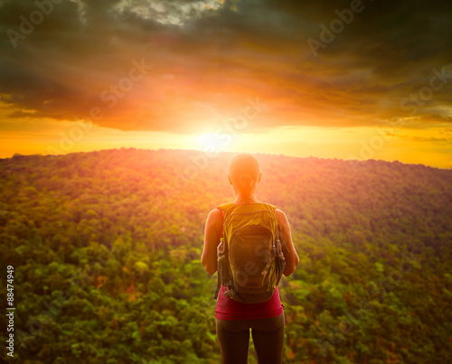 Travelling woman with backpack looking an inspiring sunset. photo
