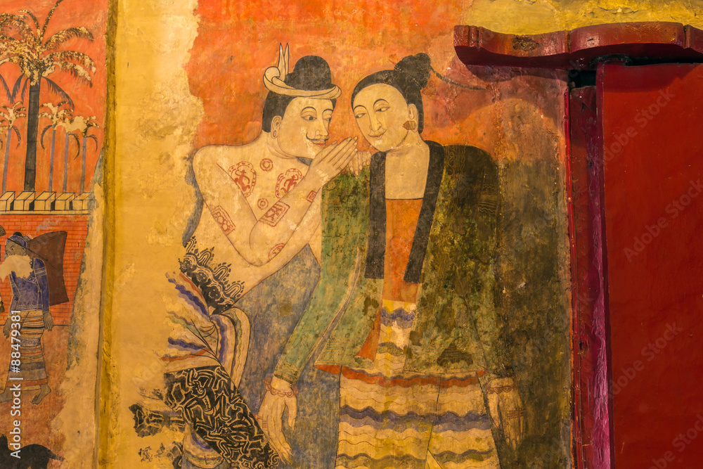Fototapeta premium Traditional Thai mural painting on temple wall at Wat Phumin in Nan, Thailand. The famous mural painting of a man whispering to the ear of a woman.