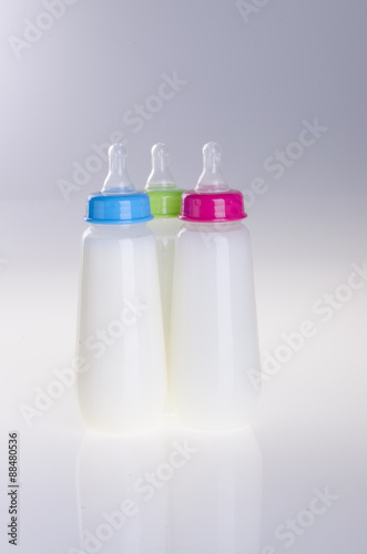 Baby bottle with milk on background