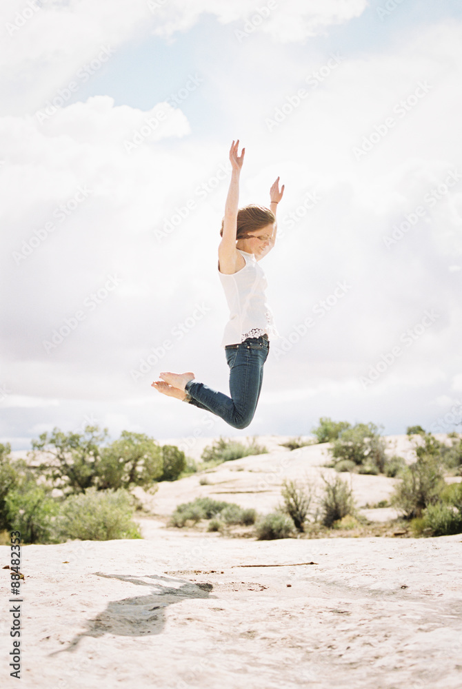 Barefoot woman wearing jeans, jumping up in the air Barefoot woman wearing jeans, jumping up in the air